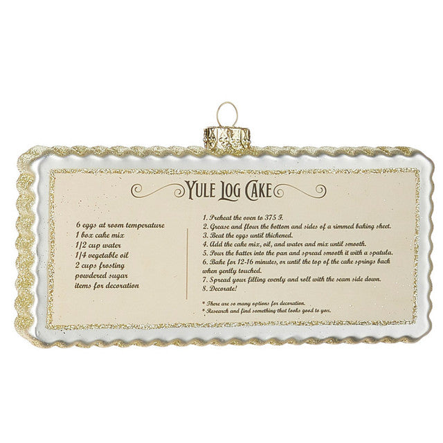 6" Holiday Recipe Ornaments. White with Gold Glitter. Yule Log Cake Recipe. Rectangular Shape with Scalloped Edges. 6"L x 3.5"H x 1"W. Made of Glass