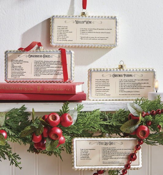 6" Holiday Recipe Ornaments. White with Gold Glitter. Four Recipes: Christmas Pudding, Gingerbread Cookies, Mulled Wine, Yule Log Cake. Rectangular Shape with Scalloped Edges. 6"L x 3.5"H x 1"W. Made of Glass